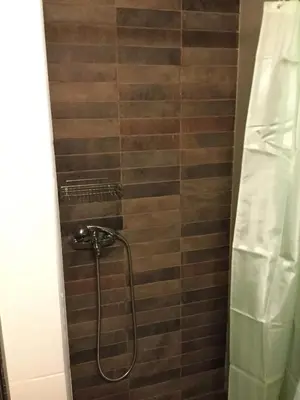 a shower with a hose in a bathroom at A medieval windmill tower 2bedrooms in the heart of old town with magnificent panoramic seaview and cityview in Rhodes Town