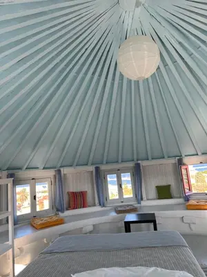 a bedroom with a blue roof with a bed and windows at A medieval windmill tower 2bedrooms in the heart of old town with magnificent panoramic seaview and cityview in Rhodes Town