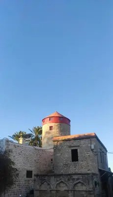 an old lighthouse on top of a building at A medieval windmill tower 2bedrooms in the heart of old town with magnificent panoramic seaview and cityview in Rhodes Town