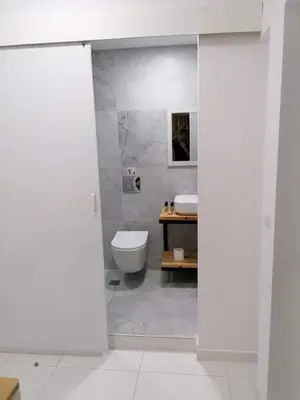 a white bathroom with a toilet and a sink at Jz Plus e'Bella in Rhodes Town