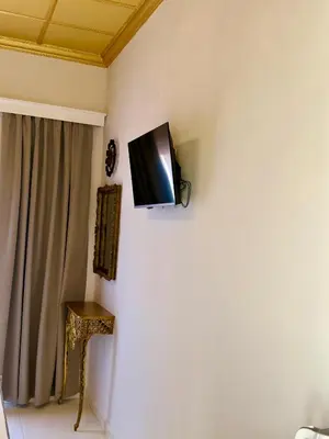 a flat screen tv hanging on the corner of a wall at Jz Plus e'Bella in Rhodes Town