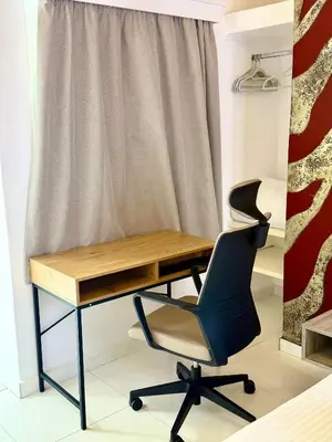 a desk and a chair in front of a curtain at Jz Plus e'Bella in Rhodes Town