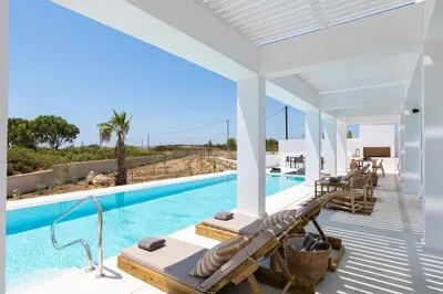 a villa with a swimming pool and a patio at Seacarf Villa, 3 magnificent properties in Lachania beach, Bedrooms 12, Sleeps 27 in Lachania