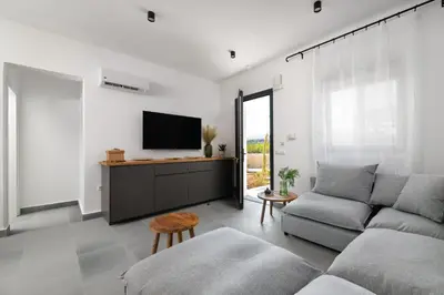 a living room with a couch and a tv at Seacarf Villa, 3 magnificent properties in Lachania beach, Bedrooms 12, Sleeps 27 in Lachania