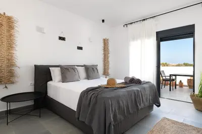 a bedroom with a large bed and a balcony at Seacarf Villa, 3 magnificent properties in Lachania beach, Bedrooms 12, Sleeps 27 in Lachania