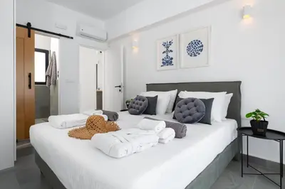 a bedroom with a large white bed with white pillows at Seacarf Villa, 3 magnificent properties in Lachania beach, Bedrooms 12, Sleeps 27 in Lachania