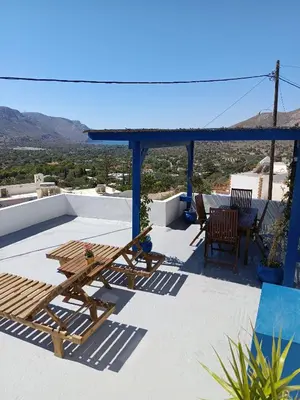 a patio with a table and chairs on a roof at IVISKOS House, Megalo Horio village, Tilos Island in Megálon Choríon