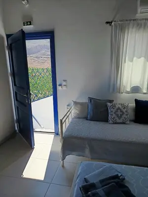 a living room with a couch and a sliding glass door at IVISKOS House, Megalo Horio village, Tilos Island in Megálon Choríon