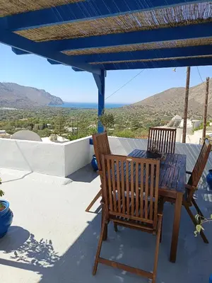 a table and two chairs on a patio with a view at IVISKOS House, Megalo Horio village, Tilos Island in Megálon Choríon