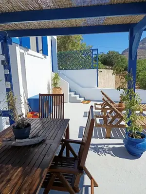 a wooden table and chairs on a patio at IVISKOS House, Megalo Horio village, Tilos Island in Megálon Choríon