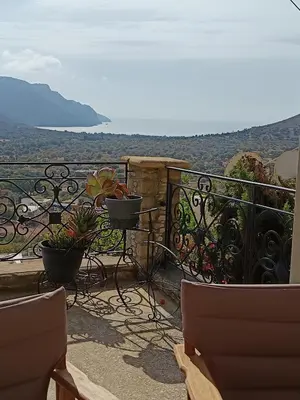 a balcony with chairs and a view of the ocean at ILAKATI House, Megalo Horio village, Tilos Island in Megálon Choríon