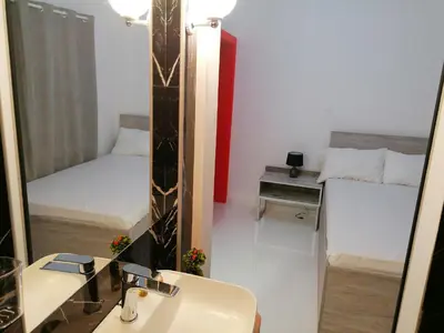 a bathroom with a mirror and a sink and a bed at Jz Plus Classio in Rhodes Town
