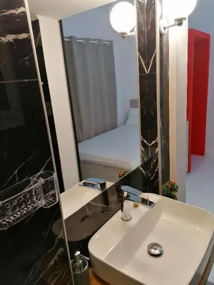 a bathroom with a white sink and a mirror at Jz Plus Classio in Rhodes Town