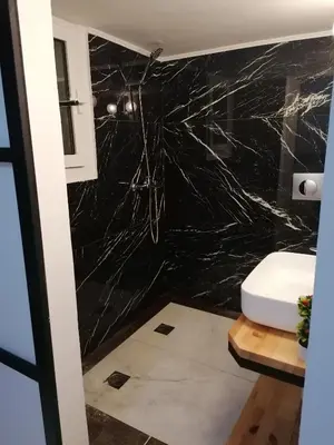 a bathroom with a black marble wall at Jz Plus Classio in Rhodes Town
