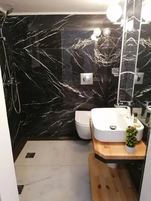 a bathroom with a white sink and a black wall at Jz Plus Classio in Rhodes Town