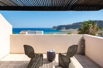 two chairs on a balcony with a view of the ocean at Lindos Villa Fadia with Private Pool in Líndos