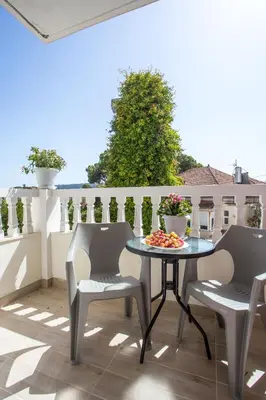 a table and two chairs on a balcony with a table at Economisa Apartments in Ialyssos
