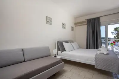 a living room with a bed and a couch at Economisa Apartments in Ialyssos
