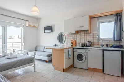 a kitchen and living room with a washer and dryer at Economisa Apartments in Ialyssos