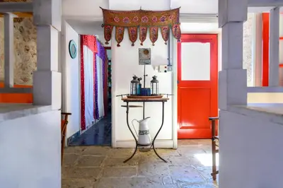 a hallway with a red door and a table at Aphrodite Villas Halki - Studio Rosa in Halki