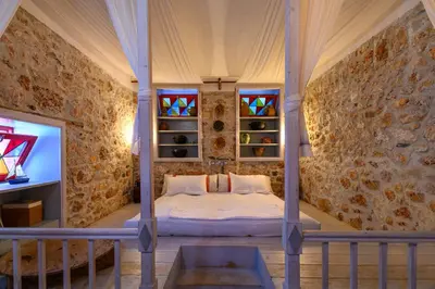 a bedroom with a bed and stained glass windows at Aphrodite Villas Halki - Studio Rosa in Halki