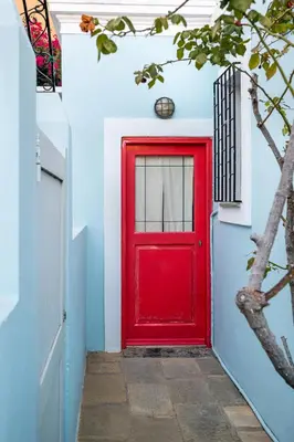 a red door on a blue and white wall at Aphrodite Villas Halki - Studio Rosa in Halki