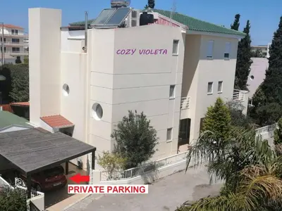 a white building with the words easy watch and private parking at Cozy Violeta in Ialyssos