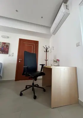 a black chair sitting in a room with a desk at Cozy Violeta in Ialyssos