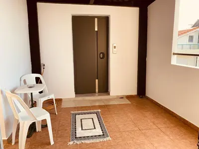 a hallway with two white chairs and a door at Cozy Violeta in Ialyssos