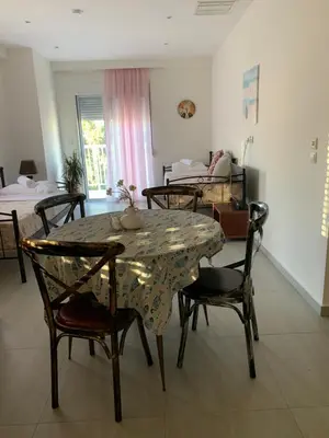 a dining room with a table and chairs with beds at Cozy Violeta in Ialyssos