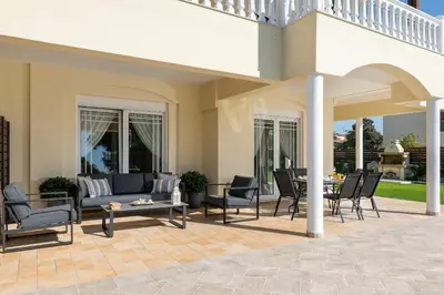 a patio with chairs and a couch and a table at Villa Montefile in Triánta