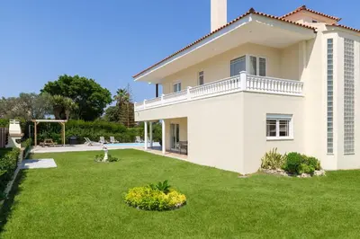 a large white house with a green yard at Villa Montefile in Triánta