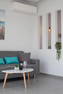 a living room with a couch and a table at The Azure Blue Apt Faliraki in Faliraki