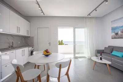 a kitchen and living room with a table and chairs at The Azure Blue Apt Faliraki in Faliraki