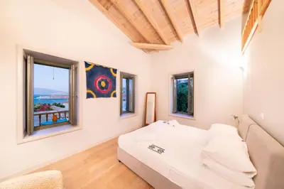 a living room with a bed and windows at Aphrodite Villas Halki - Villa Bougainvillea in Halki