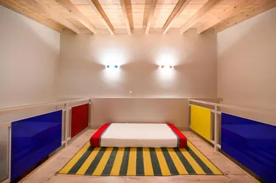 a bed in a room with colorful paint on the walls at Aphrodite Villas Halki - Villa Bougainvillea in Halki
