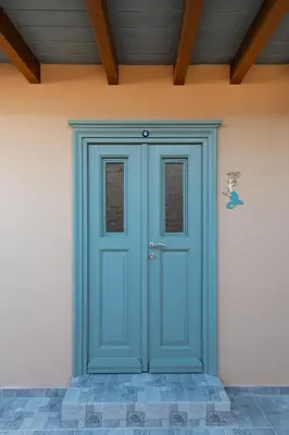 a blue door on the side of a house at Aphrodite Villas Halki - Villa Bougainvillea in Halki