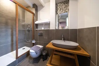 a bathroom with a sink and a shower and a toilet at Aphrodite Villas Halki - Villa Bougainvillea in Halki