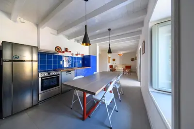 a kitchen with a wooden table and blue cabinets at Aphrodite Villas Halki - Villa Bougainvillea in Halki