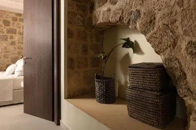 a room with a stone wall and a vase with a plant at San Antonio Luxury Apartments, Medieval Town in Rhodes Town