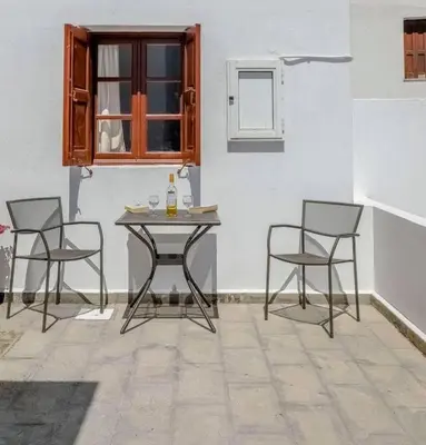 a table and chairs in a room with a window at Barvas studios Lindos in Líndos