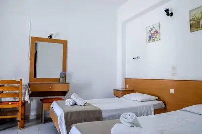 a hotel room with two beds and a mirror at Barvas studios Lindos in Líndos