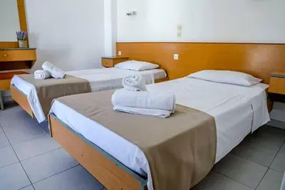 two beds in a hotel room with towels on them at Barvas studios Lindos in Líndos