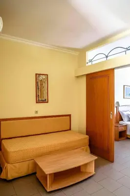 a bedroom with a bed and a table in it at Coloma Apartments Pefkos in Pefki Rhodes