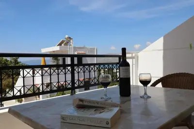 a bottle of wine and two glasses on a table at Coloma Apartments Pefkos in Pefki Rhodes