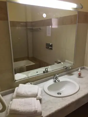 a bathroom with a sink and a mirror and a tub at Coloma Apartments Pefkos in Pefki Rhodes