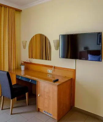 a room with a desk with a television on the wall at Coloma Apartments Pefkos in Pefki Rhodes