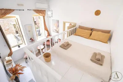 a white bedroom with a bed with towels on it at Mansion House(est.c1890)-Daedalus in Halki