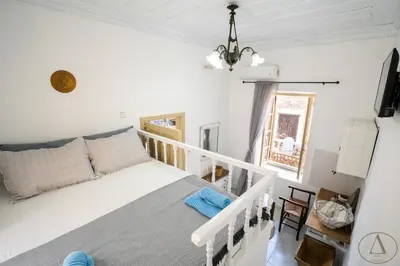 a bedroom with a white bed and a window at Mansion House(est.c1890)-Daedalus in Halki