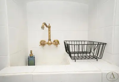 a bath tub with a faucet on a white wall at Mansion House(est.c1890)-Daedalus in Halki
